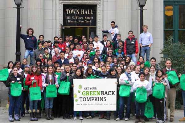 town gov staff with green new deal sign in front of town hall